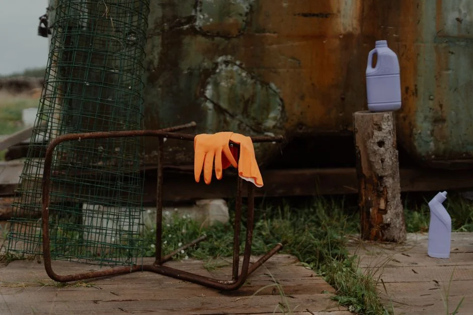 Anonymous person wearing yellow latex gloves washing golden faucet with sponge in modern bathroom while cleaning house